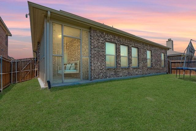 273 Pitt Cir, Fate, TX 75189 - back of property at dusk with a trampoline and brick siding