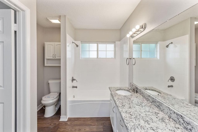 2502 Lake Valley Dr, Garland, TX 75040 - full bath with toilet, bathtub / shower combination, vanity, wood finished floors, and healthy amount of natural light
