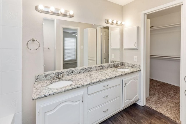 2502 Lake Valley Dr, Garland, TX 75040 - bathroom with double vanity, a walk in closet, and wood finished floors