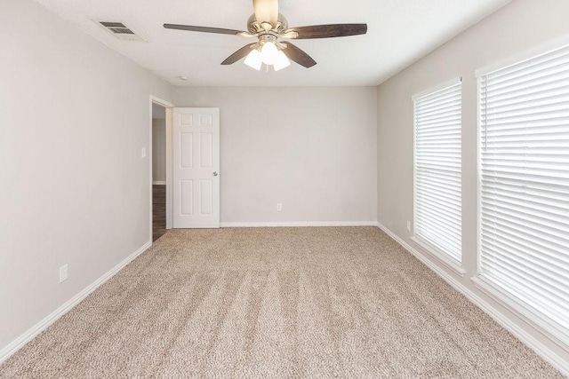 2502 Lake Valley Dr, Garland, TX 75040 - empty room featuring plenty of natural light, carpet flooring, ceiling fan, and baseboards