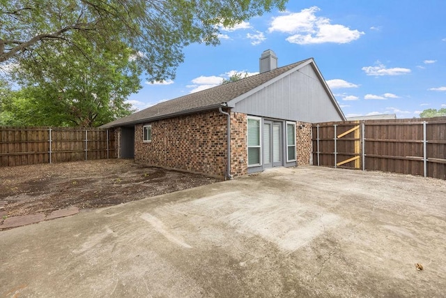 2502 Lake Valley Dr, Garland, TX 75040 - rear view of house with brick siding, a chimney, a fenced backyard, and roof with shingles
