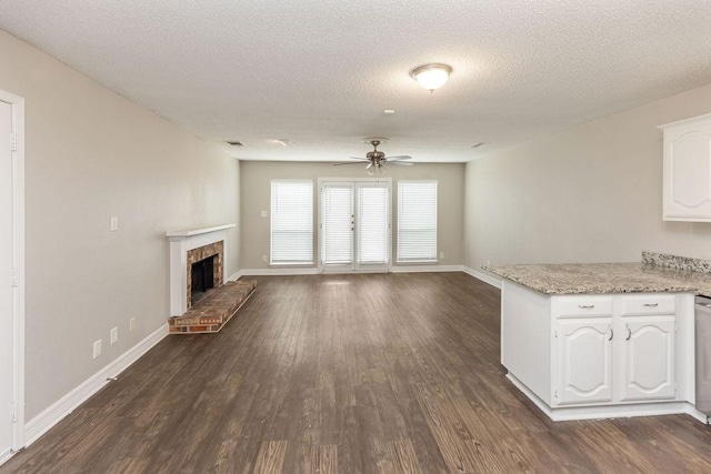2502 Lake Valley Dr, Garland, TX 75040 - unfurnished living room featuring dark wood-style flooring, baseboards, ceiling fan, and a textured ceiling