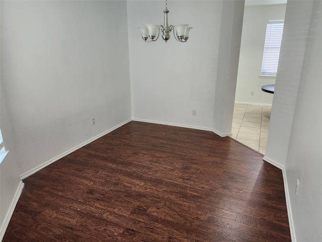 4026 Carrington Dr, Garland, TX 75043 - unfurnished dining area with a chandelier, wood finished floors, and baseboards