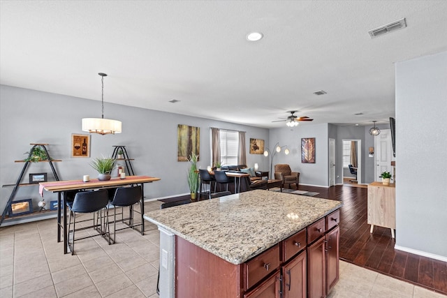 9129 Blackstone Dr, Providence Village, TX 76227 - kitchen with a center island, pendant lighting, open floor plan, a ceiling fan, and baseboards