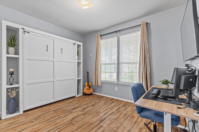 9129 Blackstone Dr, Providence Village, TX 76227 - home office featuring light wood-style floors, baseboards, and a textured ceiling