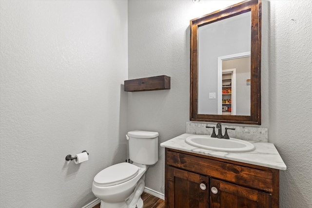 2132 Dewitt Ln, Providence Village, TX 76227 - half bathroom featuring vanity, toilet, wood finished floors, and baseboards