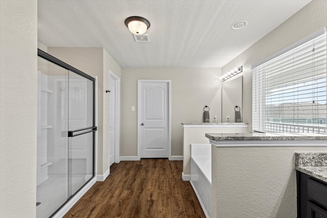 2132 Dewitt Ln, Providence Village, TX 76227 - full bath with vanity, a stall shower, wood finished floors, a bath, and a textured ceiling