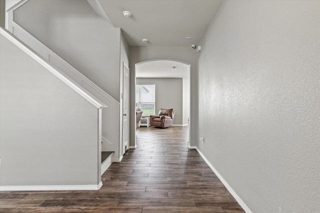 2132 Dewitt Ln, Providence Village, TX 76227 - hall with arched walkways, dark wood finished floors, a textured wall, baseboards, and stairs