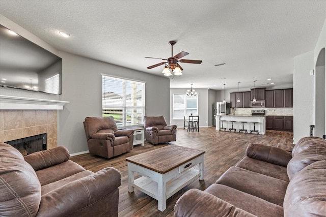 2132 Dewitt Ln, Providence Village, TX 76227 - living room with a ceiling fan, a fireplace, wood finished floors, a chandelier, and a textured ceiling