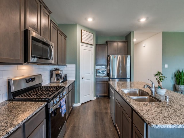 519 Stampede Ln, Princeton, TX 75407 - kitchen featuring stainless steel appliances, a sink, dark wood-style floors, a kitchen island with sink, and dark brown cabinetry