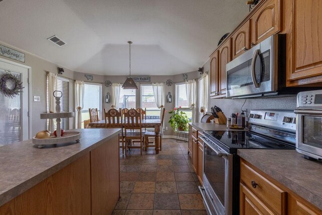 1551 Whiterock Dr, Midlothian, TX 76065 - kitchen with appliances with stainless steel finishes, dark countertops, lofted ceiling, pendant lighting, and dark stone finish flooring