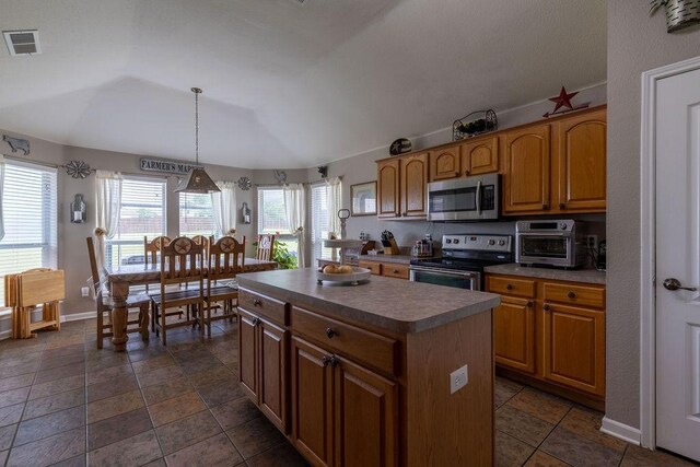 1551 Whiterock Dr, Midlothian, TX 76065 - kitchen with stainless steel appliances, a center island, lofted ceiling, brown cabinets, and decorative light fixtures