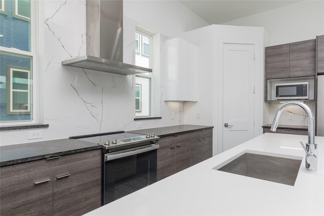 2235 Lovedale Ave Unit 102, Dallas, TX 75235 - kitchen featuring wall chimney range hood, stainless steel appliances, a sink, dark brown cabinetry, and modern cabinets