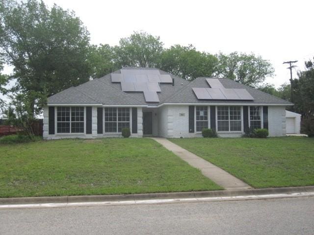101 Ginger Dr, Pottsboro, TX 75076 - view of front of property featuring roof mounted solar panels, a front lawn, and a shingled roof
