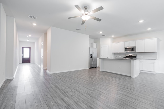 624 Beltrand Ln, Fate, TX 75087 - kitchen featuring appliances with stainless steel finishes, open floor plan, light wood-style floors, white cabinetry, and recessed lighting
