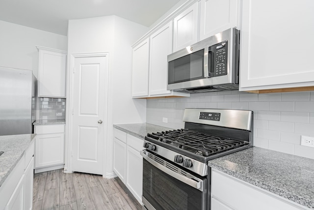 624 Beltrand Ln, Fate, TX 75087 - kitchen featuring appliances with stainless steel finishes, white cabinets, backsplash, light wood-type flooring, and light stone countertops