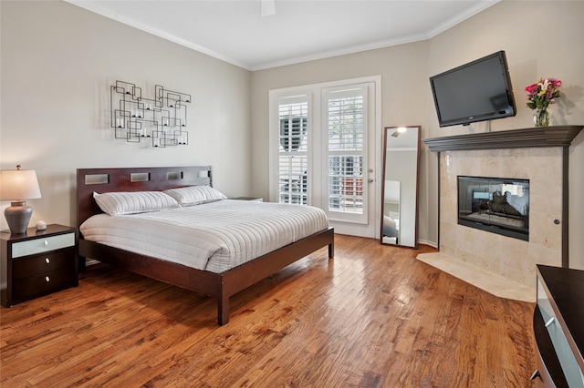 3908 Sagamore Hill Ct, Plano, TX 75025 - bedroom with crown molding, wood finished floors, a tile fireplace, access to outside, and a ceiling fan