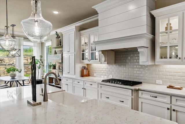 3480 Newport Dr, Prosper, TX 75078 - kitchen with stainless steel gas cooktop, a sink, crown molding, white cabinetry, and tasteful backsplash