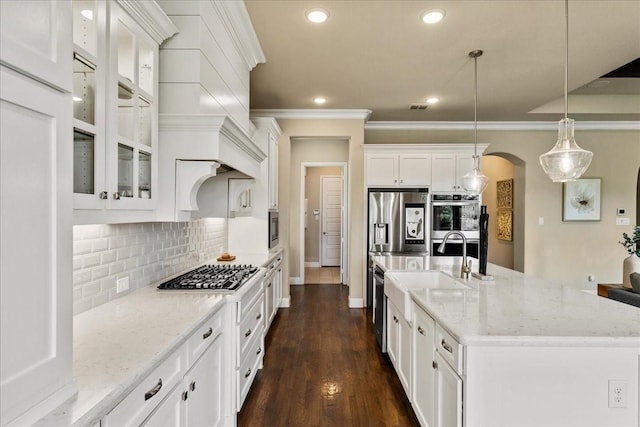 3480 Newport Dr, Prosper, TX 75078 - kitchen with stainless steel appliances, arched walkways, white cabinets, decorative backsplash, and recessed lighting