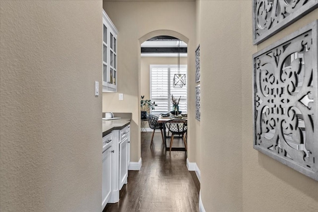 3480 Newport Dr, Prosper, TX 75078 - corridor featuring a textured wall, dark wood-style flooring, arched walkways, and baseboards