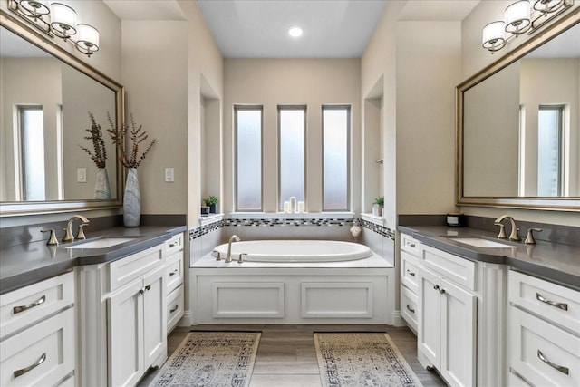 3480 Newport Dr, Prosper, TX 75078 - full bath with two vanities, a garden tub, wood finished floors, and recessed lighting