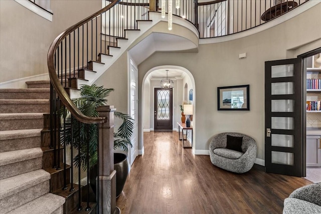 3480 Newport Dr, Prosper, TX 75078 - foyer featuring arched walkways, stairs, wood finished floors, a towering ceiling, and baseboards