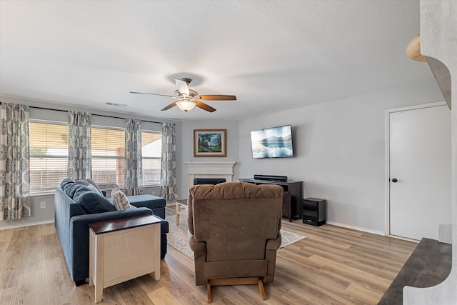 1036 Ridgetop Dr, Justin, TX 76247 - living room featuring ceiling fan, light wood-style floors, a fireplace, and baseboards