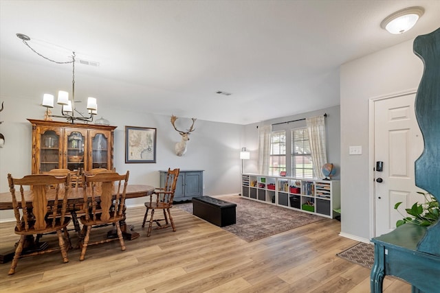 1036 Ridgetop Dr, Justin, TX 76247 - dining area with light wood finished floors, a chandelier, and baseboards