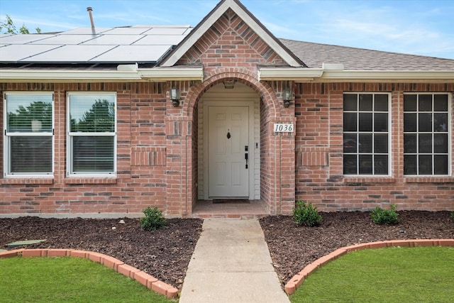 1036 Ridgetop Dr, Justin, TX 76247 - doorway to property featuring brick siding, solar panels, and roof with shingles
