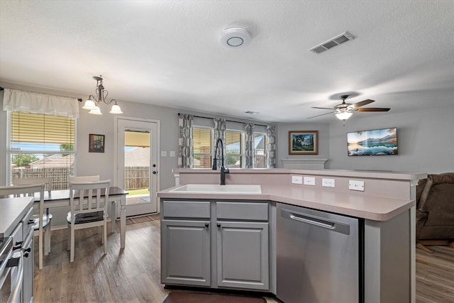 1036 Ridgetop Dr, Justin, TX 76247 - kitchen featuring dishwasher, a sink, wood finished floors, plenty of natural light, and a textured ceiling