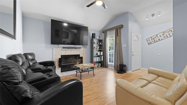 5323 Northridge Blvd, North Richland Hills, TX 76180 - living room featuring ceiling fan, vaulted ceiling, light wood-style floors, a tile fireplace, and baseboards