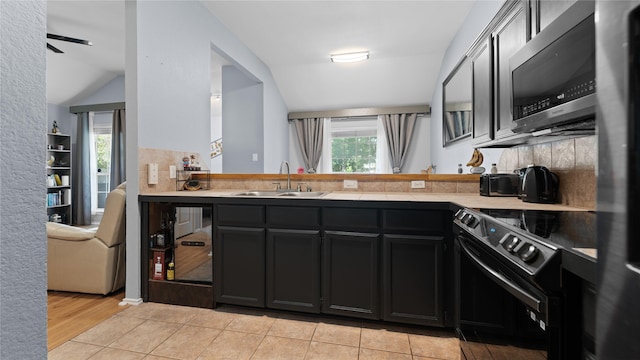 5323 Northridge Blvd, North Richland Hills, TX 76180 - kitchen featuring stainless steel appliances, a sink, a peninsula, light countertops, and dark cabinets