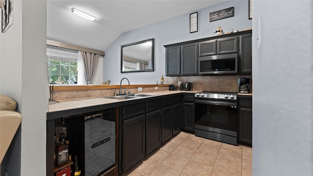 5323 Northridge Blvd, North Richland Hills, TX 76180 - kitchen with appliances with stainless steel finishes, a sink, vaulted ceiling, light tile patterned floors, and tasteful backsplash