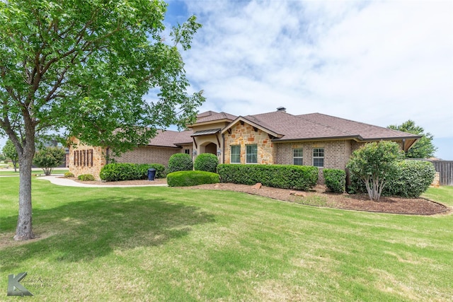 602 Prosperity Rd, Abilene, TX 79602 - view of front facade with a front yard, brick siding, stone siding, and roof with shingles