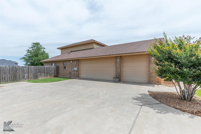 602 Prosperity Rd, Abilene, TX 79602 - view of front of house with an attached garage, driveway, brick siding, and a shingled roof