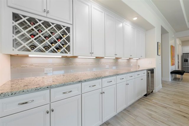 11017 Cartwright Dr, Denton, TX 76207 - kitchen with wine cooler, tasteful backsplash, white cabinetry, baseboards, and light wood-type flooring