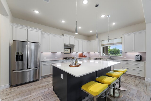 11017 Cartwright Dr, Denton, TX 76207 - kitchen featuring appliances with stainless steel finishes, a center island, tasteful backsplash, white cabinets, and light countertops