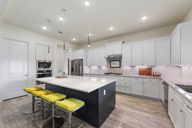 11017 Cartwright Dr, Denton, TX 76207 - kitchen featuring appliances with stainless steel finishes, a breakfast bar, white cabinets, and recessed lighting