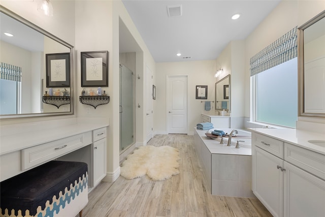 11017 Cartwright Dr, Denton, TX 76207 - bathroom with wood finished floors, a stall shower, vanity, a bath, and recessed lighting