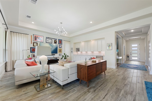 11017 Cartwright Dr, Denton, TX 76207 - living room featuring a raised ceiling, light wood-style flooring, baseboards, recessed lighting, and a chandelier