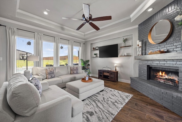 1007 Sinopa St, Caddo Mills, TX 75135 - living room with a raised ceiling, a ceiling fan, crown molding, a brick fireplace, and baseboards