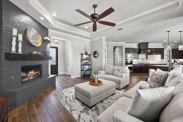 1007 Sinopa St, Caddo Mills, TX 75135 - living room with a tray ceiling, baseboards, dark wood-style floors, a ceiling fan, and a fireplace