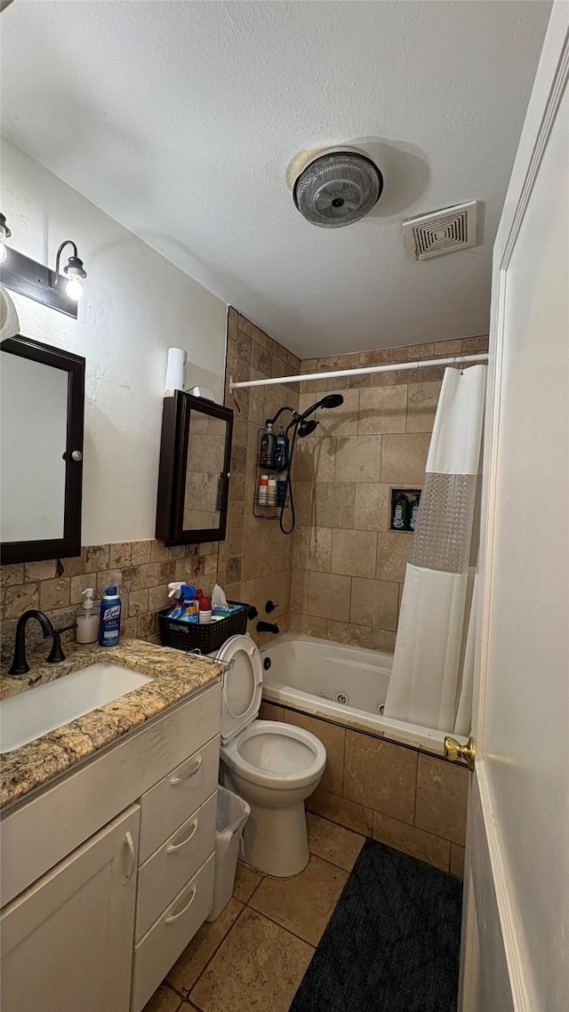 5632 Taylor Rd, River Oaks, TX 76114 - bathroom featuring tiled shower / bath, tile patterned flooring, vanity, toilet, and tile walls