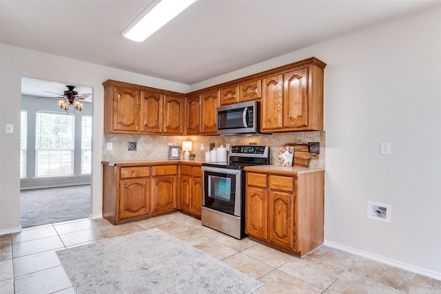 2600 Spencer Cir, Royse City, TX 75189 - kitchen featuring appliances with stainless steel finishes, brown cabinets, light countertops, and backsplash