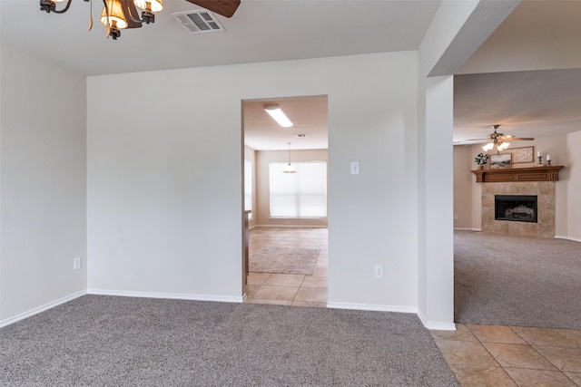2600 Spencer Cir, Royse City, TX 75189 - tiled empty room featuring carpet flooring, ceiling fan, a fireplace, and a chandelier