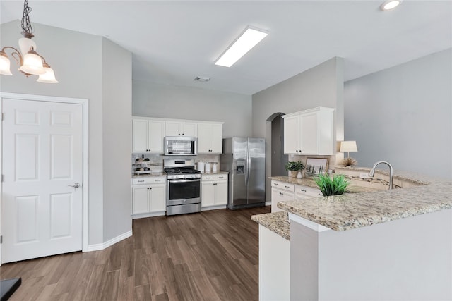 2814 Saddlebred Trl, Celina, TX 75009 - kitchen with appliances with stainless steel finishes, a sink, a peninsula, dark wood finished floors, and arched walkways