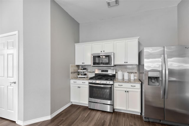 2814 Saddlebred Trl, Celina, TX 75009 - kitchen featuring appliances with stainless steel finishes, decorative backsplash, dark wood-type flooring, and light stone countertops