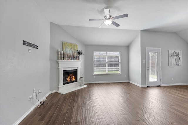 2814 Saddlebred Trl, Celina, TX 75009 - unfurnished living room featuring vaulted ceiling, dark wood-style floors, a lit fireplace, a ceiling fan, and baseboards