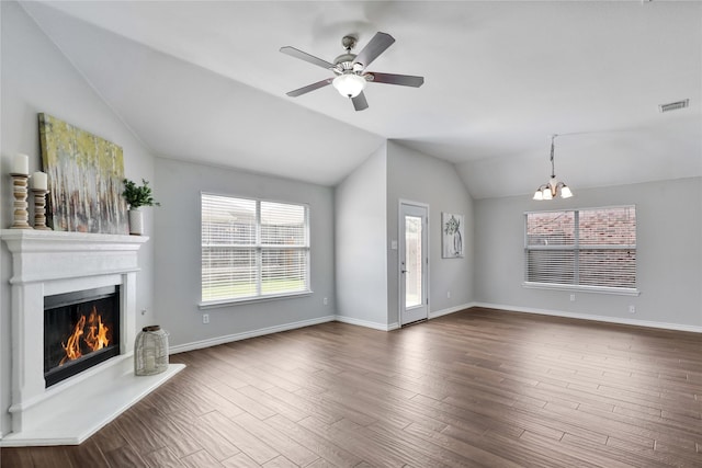 2814 Saddlebred Trl, Celina, TX 75009 - unfurnished living room featuring a chandelier, lofted ceiling, a lit fireplace, a ceiling fan, and dark wood-style flooring