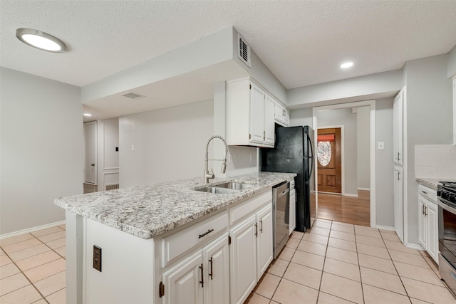 2537 Montclair Ln, Mesquite, TX 75150 - kitchen featuring a sink, stainless steel appliances, light tile patterned floors, white cabinetry, and light stone countertops